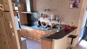 Cucina con mobili in legno, piano di lavoro nero, lavello e lampadario.