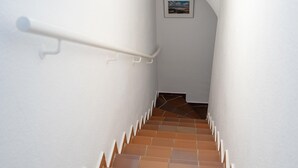 Een trap met witte muren en een schilderij aan de wand.