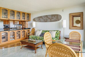 Ein Wohnzimmer mit einer Couch, Sesseln, einem Couchtisch und Holzschränken.