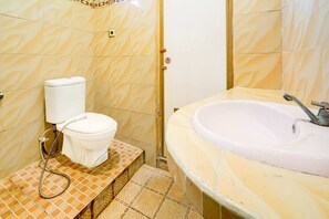 A bathroom with a toilet, sink, and tiled floor.