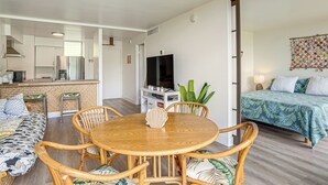 Un soggiorno moderno con zona pranzo, cucina e camera da letto con letto e televisore.
