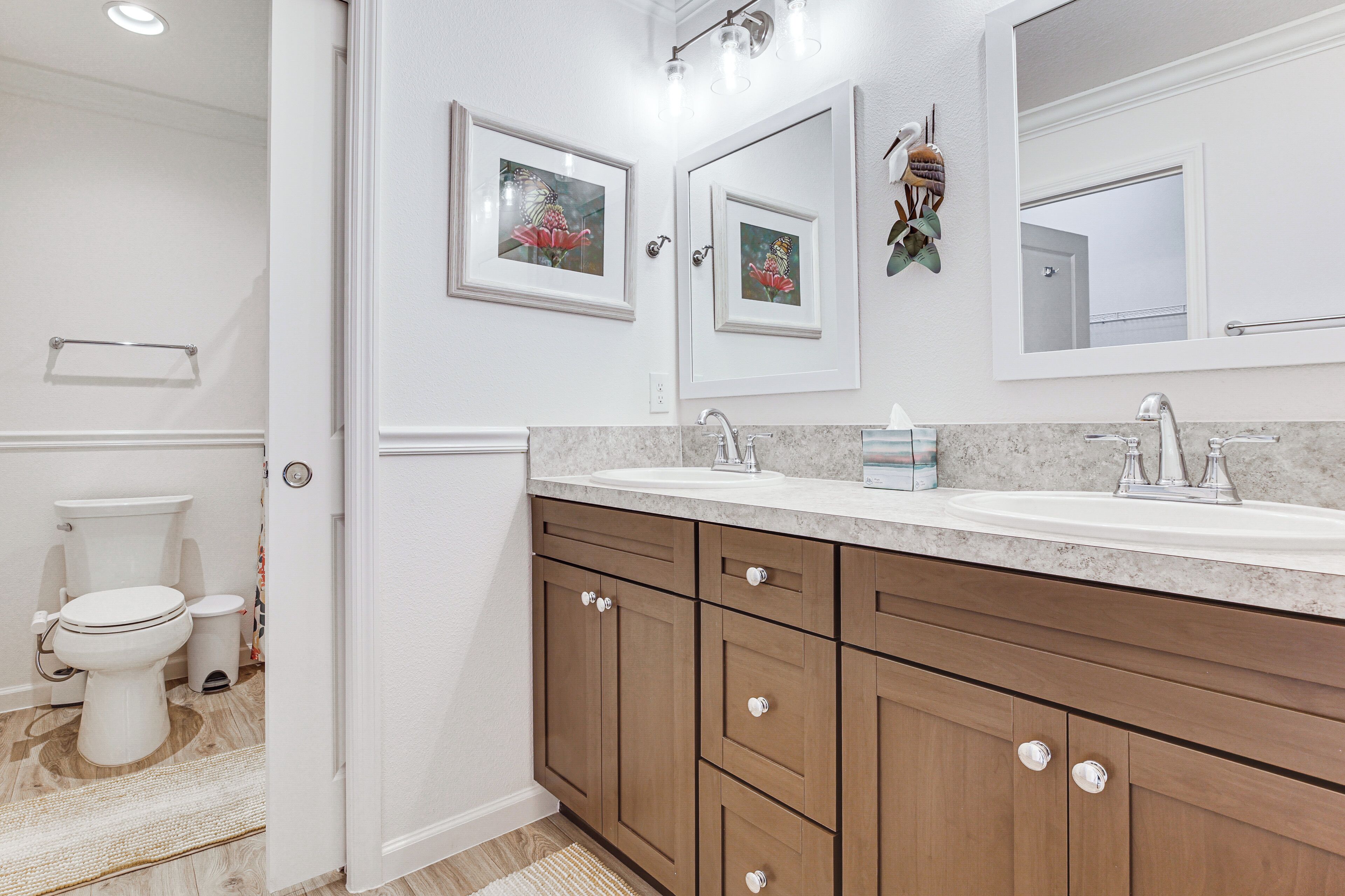 A bathroom with a toilet, a sink, and a mirror.