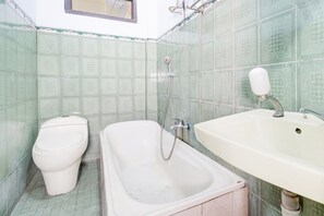 A bathroom with a toilet, a bathtub, and a sink.