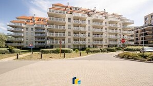 A multi-story residential building with balconies, a clear sky, and a no-entry sign. - 2BR Apartment with Terrace Near Beach (Blankenberge)