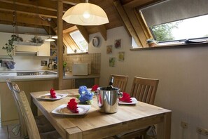 Ein Essbereich mit einem Holztisch, Stühlen, einer Kristallleuchter und einem Fenster mit Blick.
