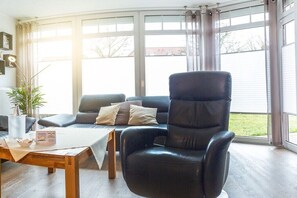 Ein modernes Wohnzimmer mit Ledersessel, Sofa und Couchtisch.
