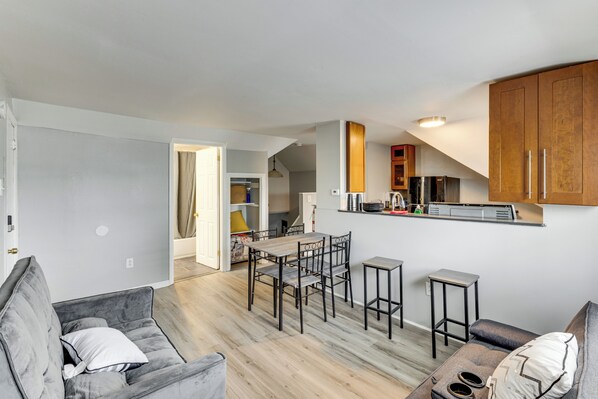 A modern apartment with a dining area, kitchen, and living space.