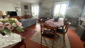 Una sala de estar bien amoblada con sofá, mesa de comedor, sillas y una araña.