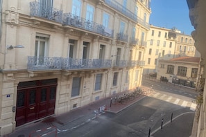 A multi-story building with ornate balconies, a red door, and bicycles parked on the sidewalk. - Beautiful Central Apartment in Montpellier (Montpellier)