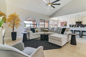 Ein modernes Wohnzimmer mit Ecksofa, Couchtisch und Topfpflanze.