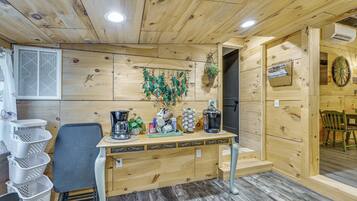 Un interior de madera con mostrador, sillas, cestas y una planta colgante.