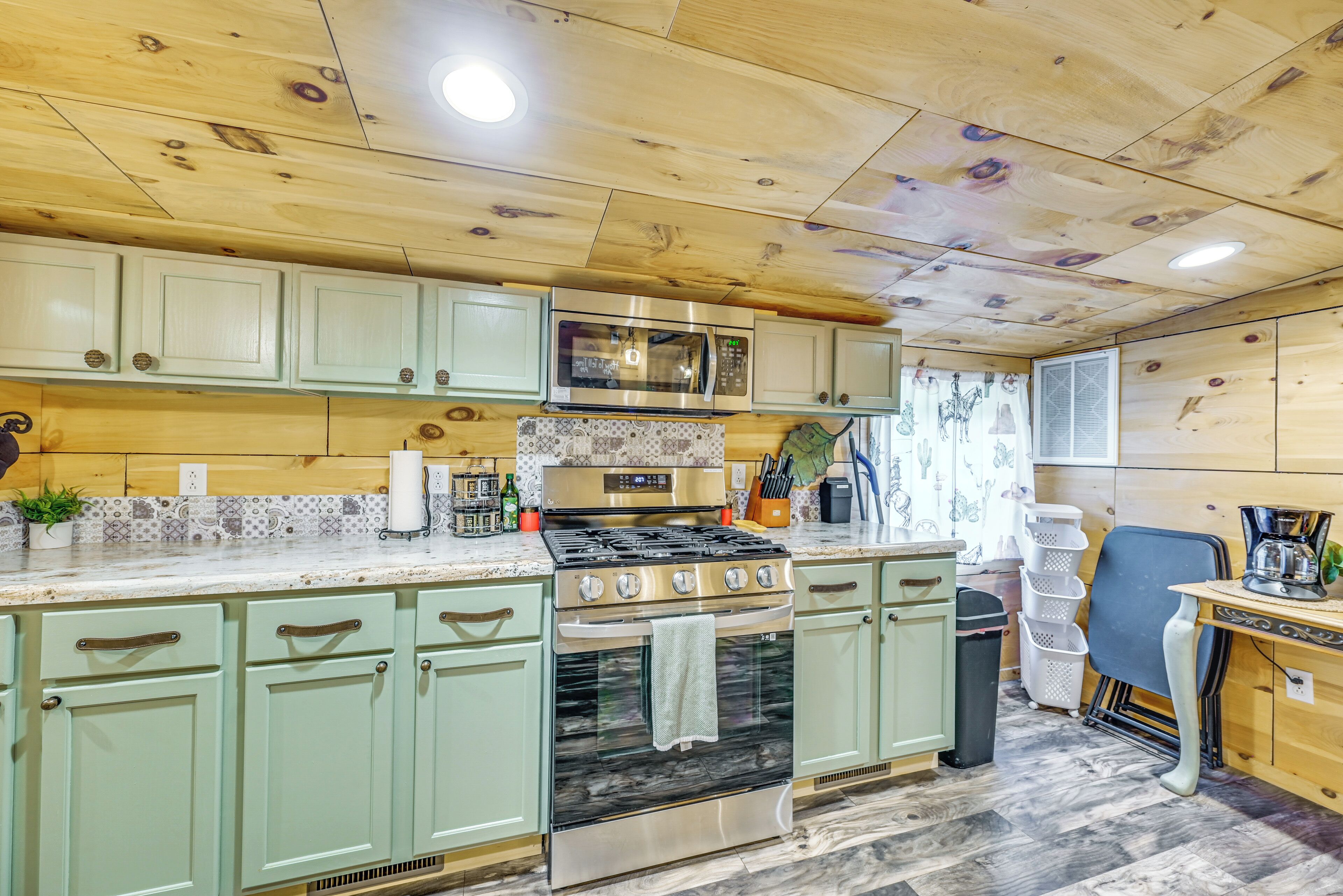 Une cuisine avec des meubles en bois, une cuisinière en acier inoxydable et un four à micro-ondes.