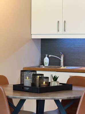 Une cuisine moderne avec un plan de travail en bois, un évier et un meuble de rangement au-dessus.