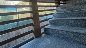 A staircase with a view of the outdoors, wooden handrails, and a modern architectural design. - 2 - Bormio Al Pradais Apartments - WEST Garden (Bormio)