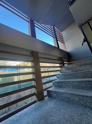 A staircase with a view of the outdoors, wooden handrails, and a modern architectural design. - 2 - Bormio Al Pradais Apartments - WEST Garden (Bormio)