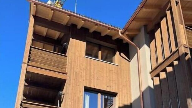 A multi-story building with a wooden facade, large windows, and a balcony. - 2 - Bormio Al Pradais Apartments - WEST Garden (Bormio)
