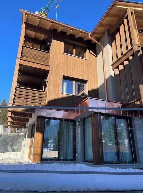 A multi-story building with a wooden facade, large windows, and a balcony. - 2 - Bormio Al Pradais Apartments - WEST Garden (Bormio)