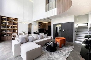 Ein modernes Wohnzimmer mit einem Ecksofa, einem Couchtisch und einem Bücherregal.