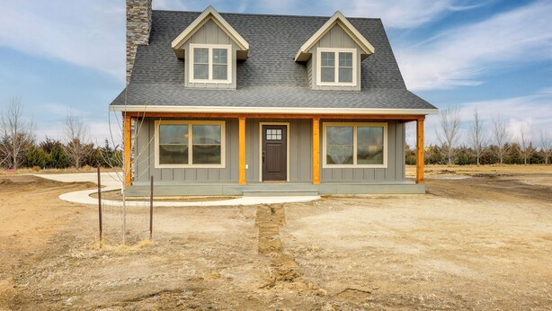 A two-story house with a grey roof, a chimney, and a front porch with a brown door. - 1 Mi to Missouri River! 2-Home Bundle for Families (Pierre)