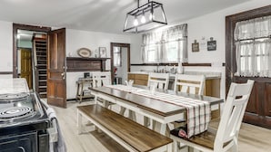 Cozinha com fogão, mesa de jantar, cadeiras e escada.