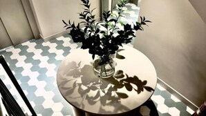 Ein runder Tisch mit einer Topfpflanze in der Mitte, umgeben von einem hexagonförmigen Bodenbelag.