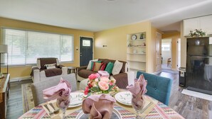A living room with a dining table set for four, a sofa, a coffee table, and a kitchen area with a refrigerator. - Easy Access to Parks, Hospital: St Louis Home (St. Louis)