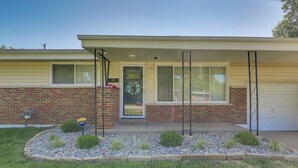 A two-story house with a garage, a front porch, and a small garden with rocks and plants. - Easy Access to Parks, Hospital: St Louis Home (St. Louis)