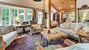A cozy room with a large bed, a sofa, a chair, and a table with a lamp.