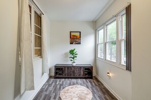 A hallway with a wooden floor, a round rug, a dark wooden bench with a plant, and a painting on the wall. - Groups & Pets Welcome! Spacious Philly Rowhouse (Philadelphia)