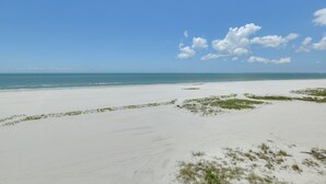 A beach with white sand and sparse vegetation. - Gulf-Front Gem w/ Pool Access on Fort Myers Beach! (Fort Myers Beach)
