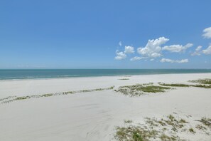A beach with white sand and sparse vegetation. - Gulf-Front Gem w/ Pool Access on Fort Myers Beach! (Fort Myers Beach)