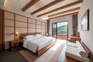 A modern hotel room with a large bed, wooden beams, a view of the mountains, and a balcony with flowers. - ALOR VALLEY HUZHOU (Huzhou)