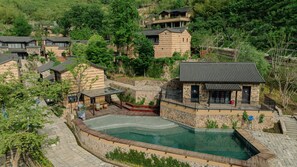 A residential area with a swimming pool, stone walls, and traditional-style houses. - ALOR VALLEY HUZHOU (Huzhou)