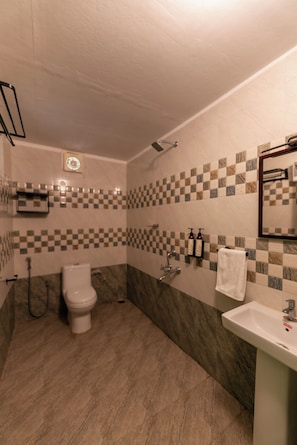 A bathroom with a toilet, sink, and shower.