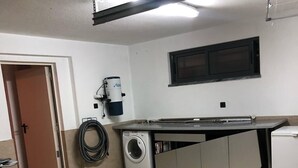 Uma lavanderia com máquina de lavar, secadora e aquecedor de água.