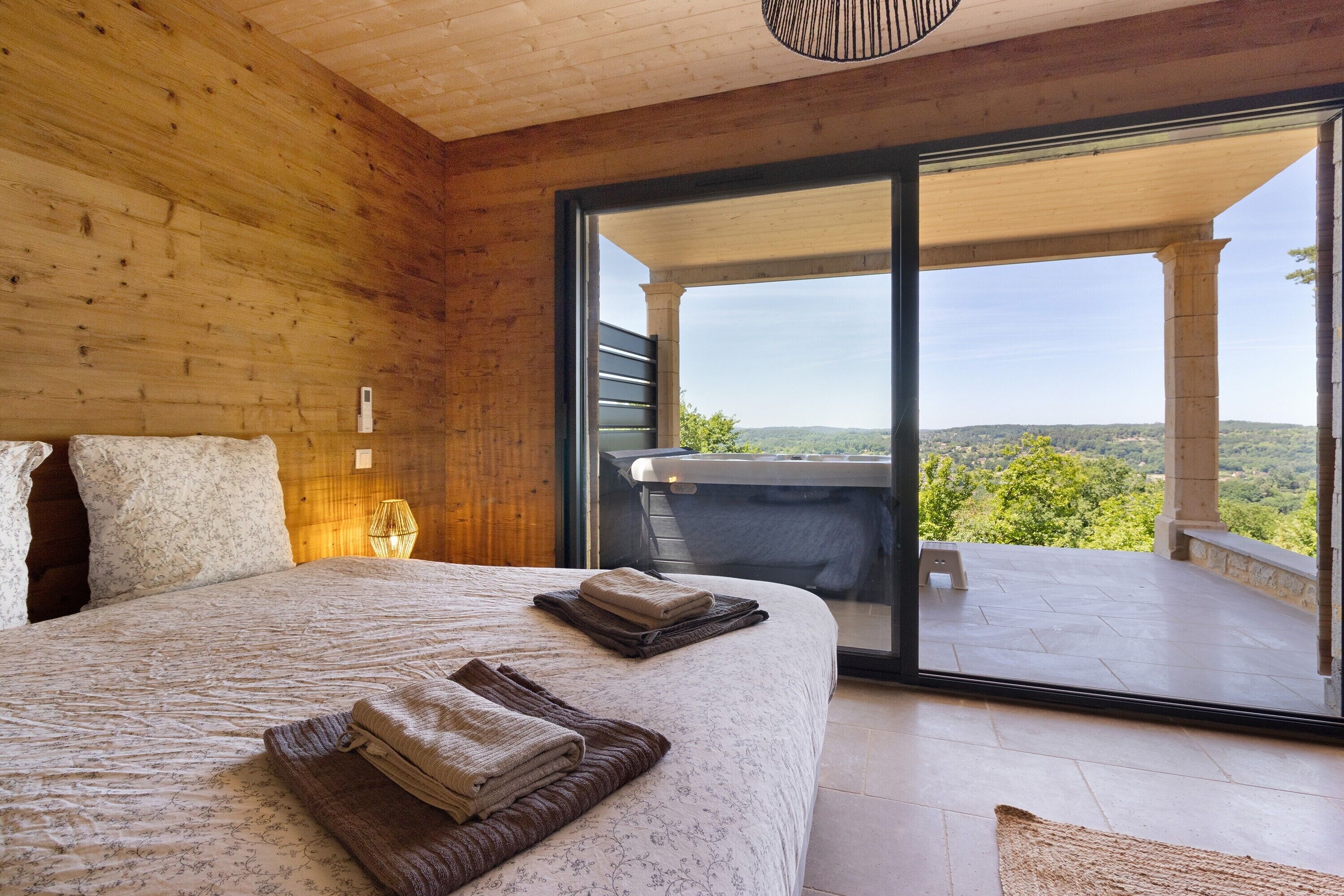 Un dormitorio con una cama grande, vistas al exterior y un balcón.