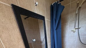 A bathroom with a white sink, a mirror, a shower, and a radiator. - Lovely 1-bedroom house in charming Limerick for a relaxing stay (Limerick)