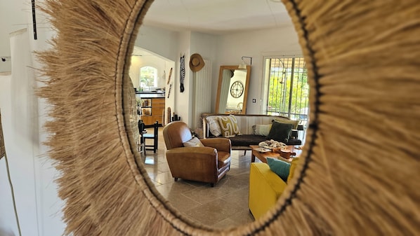 Ein Wohnzimmer mit einer Couch, einem Sessel und einem Esstisch.