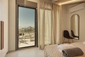 A hotel room with a bed, a chair, a large mirror, and a sliding glass door leading to an outdoor area. - Casa Dianthos, Elegant Home for Families & Groups in Pigi, Rethymno (Pigi)