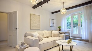 A living room with a sofa, a coffee table, and a door. - The Brick & Timber Flat by Abbey Road (London)