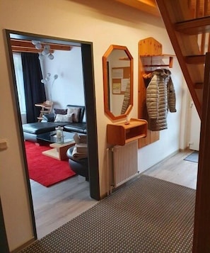 A hallway with a mirror, a coat rack, and a radiator. - Holiday home in Hooksiel with swimming pool (Hooksiel)