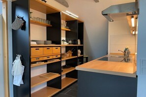 Eine moderne Küche mit Holzausbau, einer Arbeitsplatte und einem eingebauten Herd.