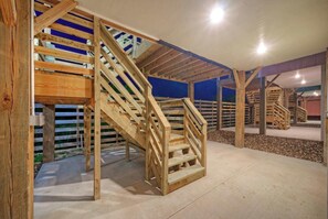 Eine HolztTreppe in einem Gebäude mit Betonboden und einer blauen Wand im Hintergrund.