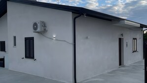 Un edifici amb teulada plana, aparells d'aire condicionat i un cel clar amb núvols.