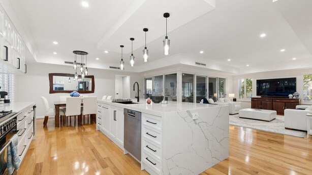 A modern kitchen with a marble island, white cabinetry, and pendant lighting. - Harbour Rise Luxury Family Retreat (Hillarys)