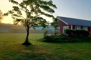 Ein Haus mit geneigtem Dach und einem gepflegten Rasen.