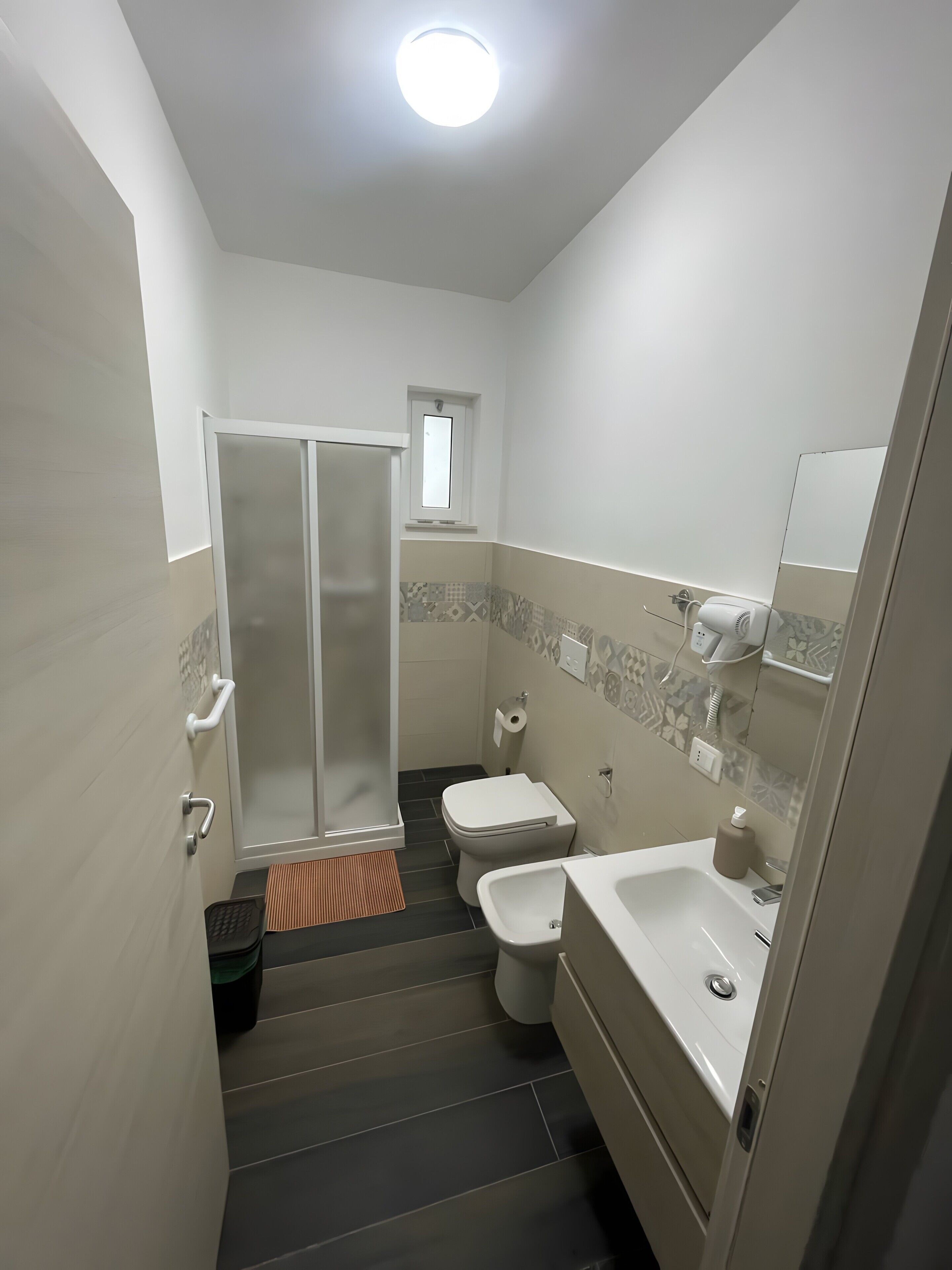 Et badeværelse med bruser, toilet, bidet og vask.