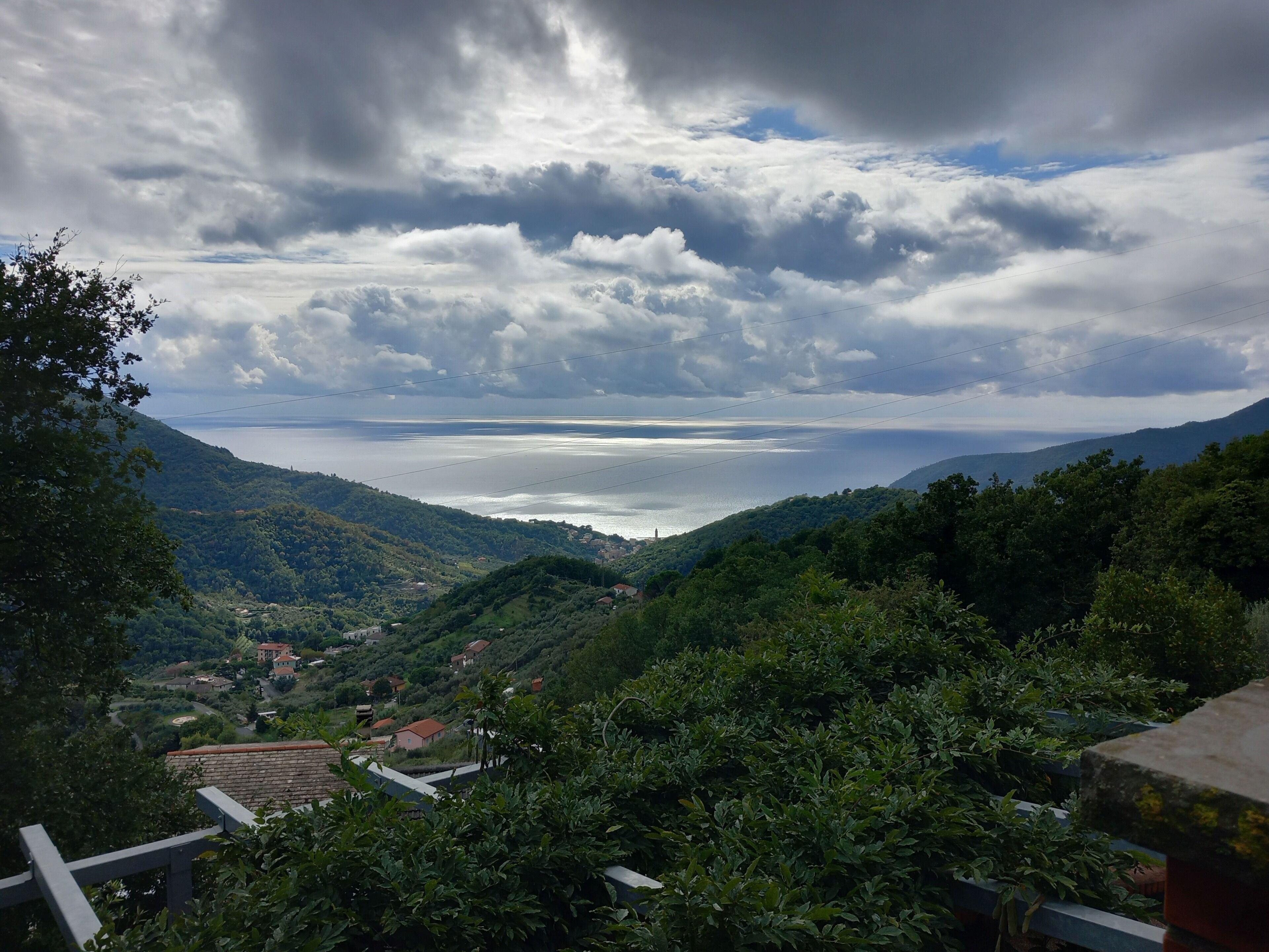 Un paysage montagneux offrant une vue sur une étendue d’eau, entouré de verdure et de bâtiments.
