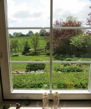 A window with a view of a garden and a statue. - Holiday home with 3 bedrooms (Malente-Neukirchen)