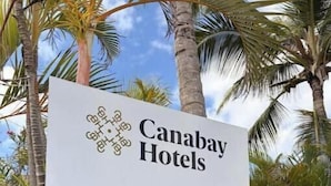 Señal para Canabay Hotels con flechas indicando el restaurante, la playa y la piscina.
